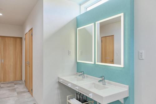 a bathroom with two sinks and a mirror at Aoyagi Stay in Shiomichō
