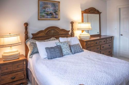 a bedroom with a bed with two lamps and a mirror at Jupiter Bay Beach Condo in Jupiter