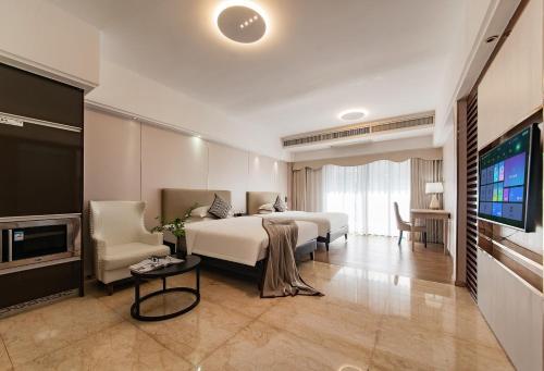 a bedroom with a bed and a flat screen tv at RoomMe HOTEL寓洣公寓佛山铂顿祖庙岭南天地店 in Foshan