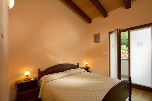 - une chambre avec un lit et une grande fenêtre dans l'établissement Turistična kmetija Štanfel, à Podsabotin