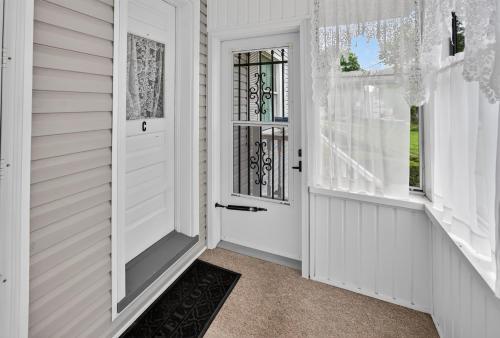 a hallway with a white door and windows at 1-Bedroom, 1-Bath Getaway in Carbondale