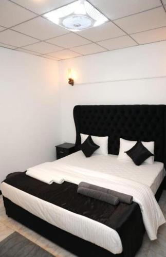 a bedroom with a large bed with black and white pillows at Breeze Climes Ella in Ella