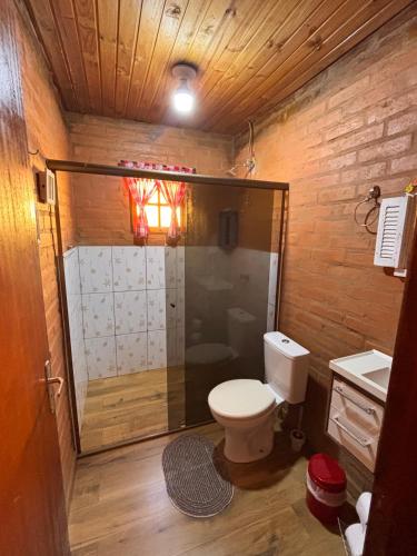 a small bathroom with a toilet and a shower at Recanto Sol Maior - Casa Lírio in Sapucaí-Mirim