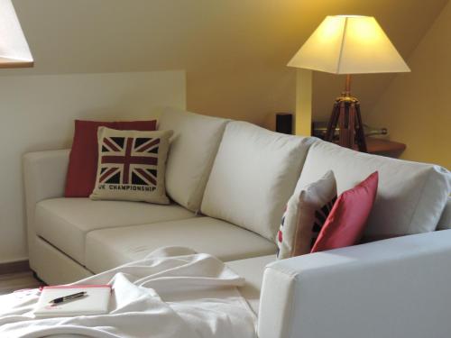 ein Wohnzimmer mit einer weißen Couch mit Kissen in der Unterkunft Maisonette zum Weststrand in Prerow