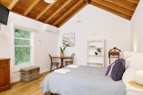 a bedroom with a bed and a table at Suma Park Estate in Point Lonsdale