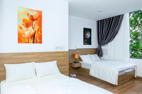 a bedroom with two beds and a window at Khách sạn Caravelle Cần Thơ 2 in Can Tho