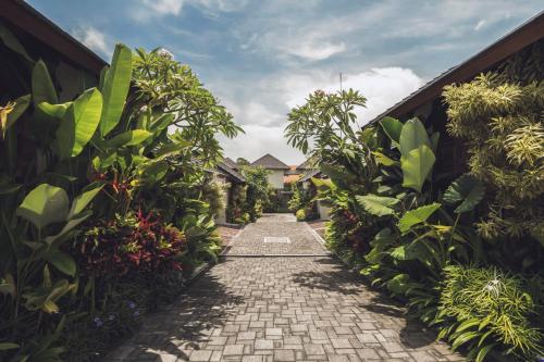 a pathway through a garden with plants at Teratai Villa Canggu by Ini Vie Hospitality in Canggu