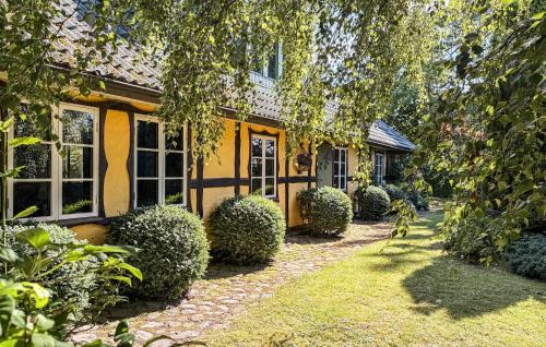 a yellow house with bushes in front of it at Villa Kalle in Åstorp