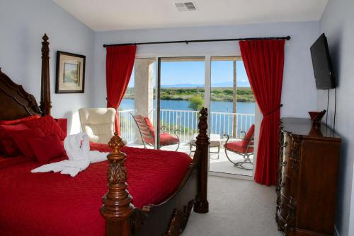 a bedroom with a bed with a red bedspread at RIVERFRONT RUBY RED HOME WITH PRIVATE DOCK & View in Bullhead City