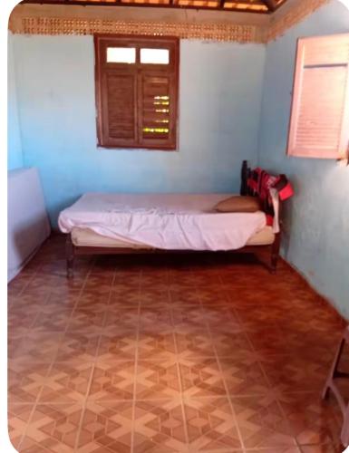 a bedroom with a bed in the corner of a room at Wana Soeiro in Marapanim