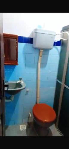 a bathroom with a red toilet and a sink at Wana Soeiro in Marapanim