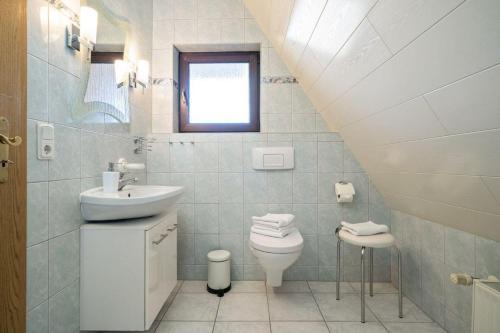 a bathroom with a sink toilet and a window at Ferienwohnung-mit-Balkon in Rechlin