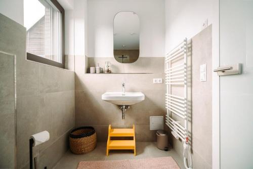 a bathroom with a sink and a mirror and a stool at Ferienwohnung-Cleo in Mirow