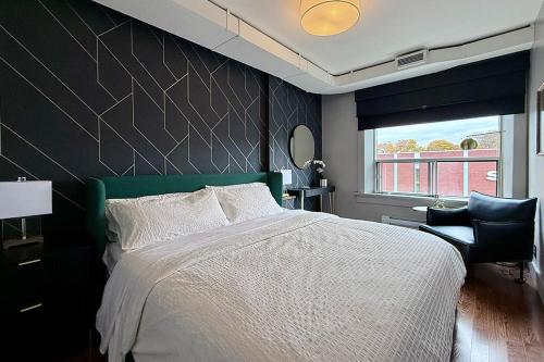 a bedroom with a white bed and a black wall at Danforth Hotel in Toronto