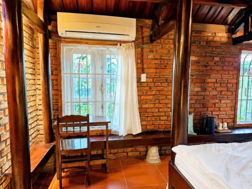 a bedroom with a bed and a table and a window at La Belle Saison Homestay Huế in Hue