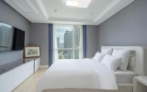 a bedroom with a large white bed and a window at BS Centum hotel in Busan