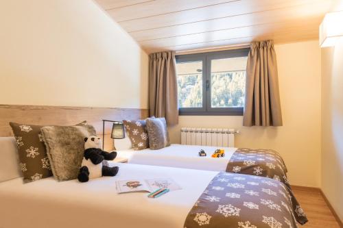 a bedroom with two beds with stuffed animals on them at Pierre & Vacances Andorra Sunari Peretol in Bordes d´Envalira