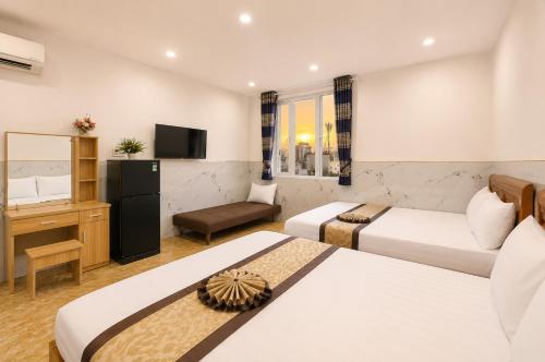 a hotel room with two beds and a television at Yoyo Airport Saigon Hotel in Ho Chi Minh City