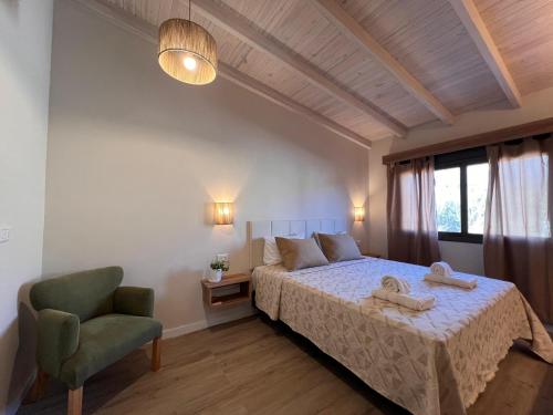 a bedroom with a bed and a green chair at Monteolivos Home & Suites in El Rincón
