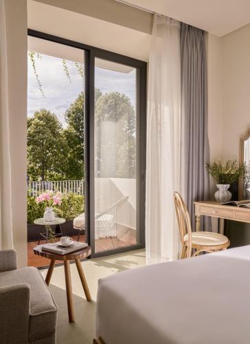 a bedroom with a bed and a living room with a balcony at LoverA Signature Hotel in Ho Chi Minh City