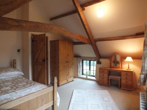 a bedroom with a bed and a dresser and a window at The Byre in Llandovery