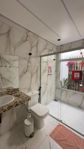 a bathroom with a toilet and a sink and a shower at Recanto Pau Brasil in Sete Lagoas
