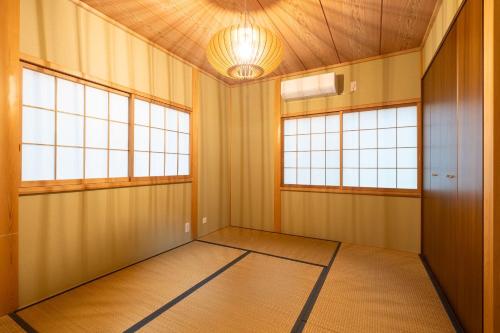 an empty room with two windows and a ceiling at S-villa Nasu 4th in Nasu