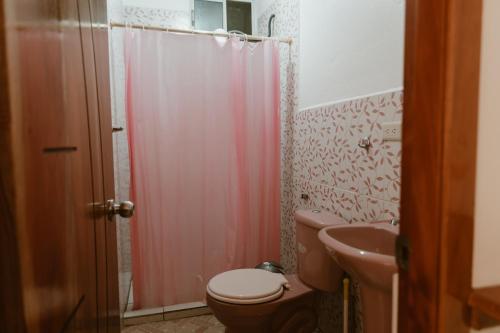 a bathroom with a pink shower curtain and a toilet at PELICAN TOURS in Puerto Baquerizo Moreno