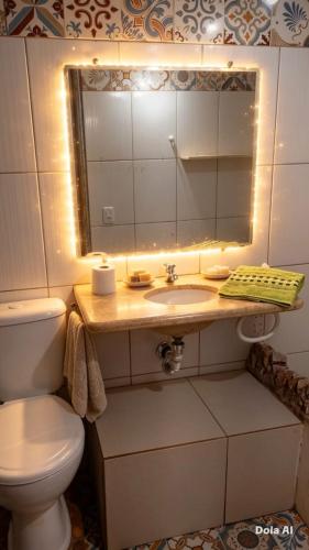 a bathroom with a toilet and a sink with a mirror at Pousada Rainha das Águas in Ilhéus