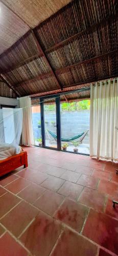 a bedroom with a bed and a room with windows at Phuc Sinh Homestay in Ben Tre