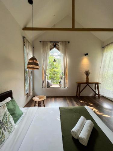 a bedroom with a bed with two towels on it at The ForRest Peace Forest แม่กำปอง in Ban Huai Kaeo
