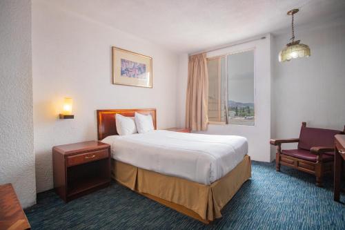 a hotel room with a bed and a window at Hotel San Jorge in Saltillo