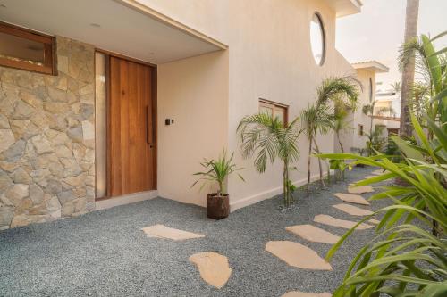 a walkway in front of a house with plants at Tiga Villas in Kuta Lombok