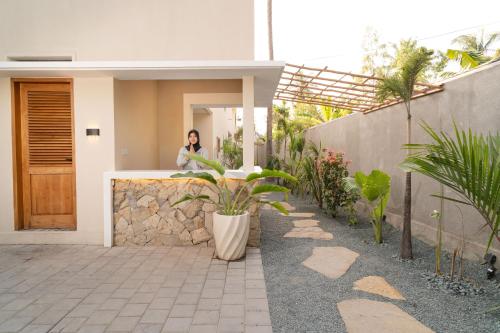 a man sitting on a counter in a house at Tiga Villas in Kuta Lombok