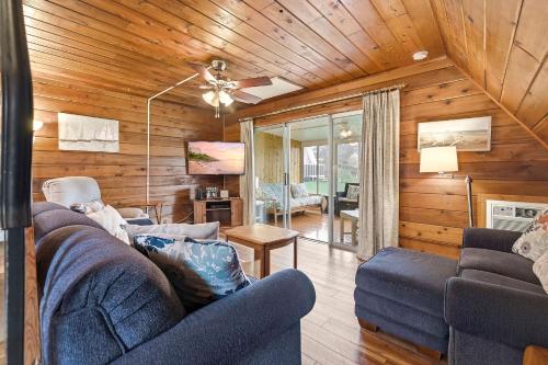 a living room with wooden walls and a blue couch at Chalet #44 in Stevensville
