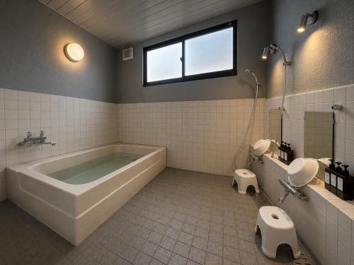 a bathroom with a tub and a toilet and a sink at Daiju Myoko - Renovated in 2025 in Myoko