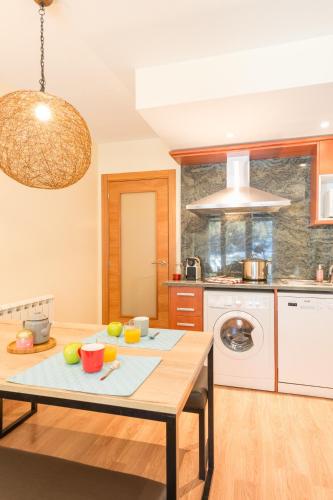 a kitchen with a wooden table in a room at Pierre & Vacances Andorra Sunari Peretol in Bordes d´Envalira