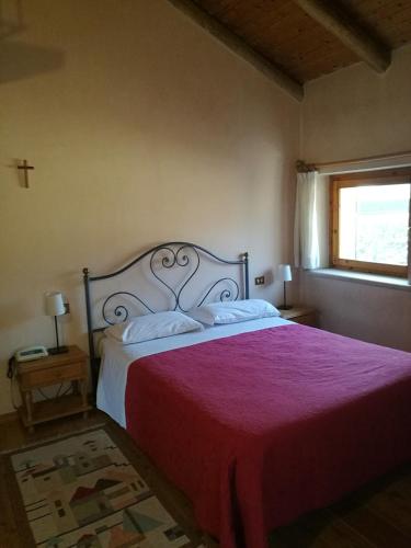 a bedroom with a large bed with a red blanket at Costa degli Ulivi in Fumane