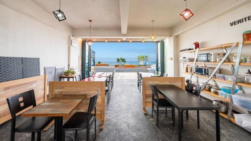 a restaurant with tables and chairs and a view of the ocean at Yangyang Verit Pension in Yangyang