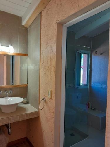 a bathroom with a glass shower and a sink at Iorana in Villa Berna