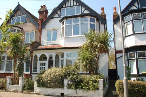 a house with palm trees in front of it at Brookview Guest House in London