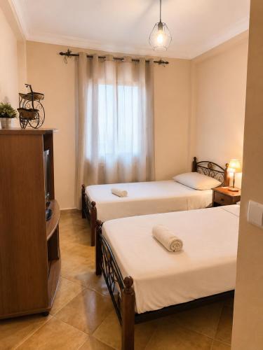 a room with three beds and a television at Résidence Tarifa in Mrarech