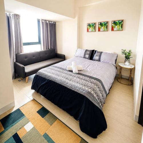 a bedroom with a large bed and a couch at The Mactan Beach Condo Staycation in Punta Engaño