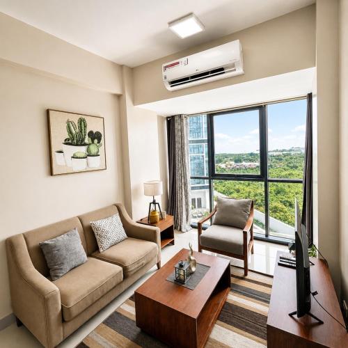 a living room with a couch and a tv at The Mactan Beach Condo Staycation in Punta Engaño