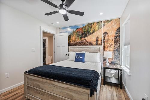 a bedroom with a bed and a painting on the wall at New Riverside Fire Pit 3BR 2.5 bath in Brewer