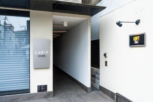 a hallway of a building with a sign on the wall at KABIN Gion in Kyoto