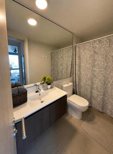 a bathroom with a sink and a toilet and a mirror at Nómade Summer Home in Iquique