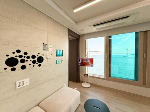 a living room with a couch and a window at Crystal Ocean House 무료주차 in Kwangan-dong