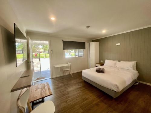 a bedroom with a bed and a table and a desk at Young Tourist Park in Young