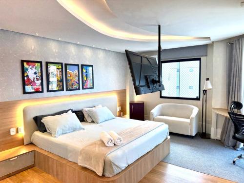 a bedroom with a large bed with a flat screen tv at Duplex de luxo em Belem in Belém